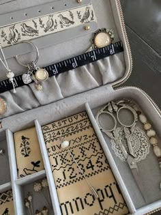 an open suitcase filled with lots of jewelry and other items on top of a table