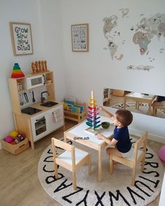 a young boy sitting at a table in a play room