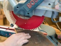 a person using a circular saw to cut wood