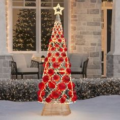 a lighted christmas tree in front of a house