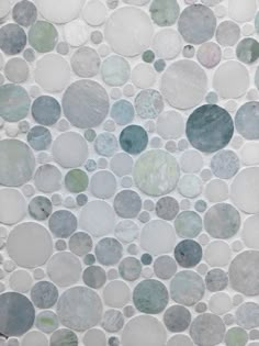 a tile wall that has circles on it and is made out of various colored stones