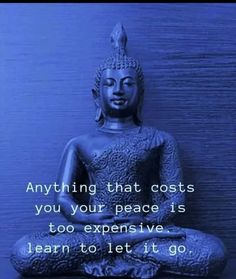 a buddha statue sitting in front of a blue wall with an inspirational quote on it