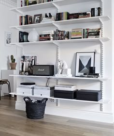 a white book shelf filled with lots of books and other items on top of it