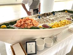 a man standing next to a table filled with different types of seafood and other foods