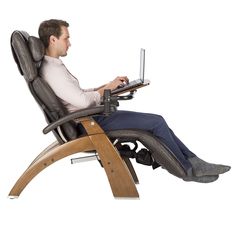 a man sitting in a chair using a laptop computer