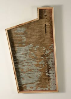 a piece of wood that has been stained blue and brown with peeling paint on it