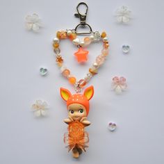 a keychain with an animal and beads attached to it on a white surface