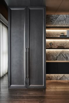 an empty room with wooden flooring and gray cupboards on the wall next to it