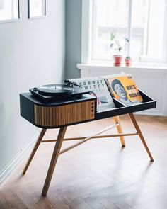 a turntable with vinyl records on it in front of a window