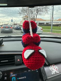 a stuffed animal hanging from the dashboard of a car