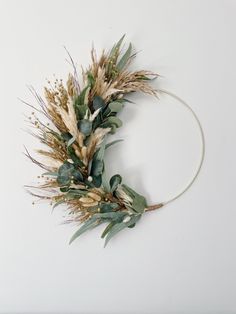 a wreath made out of dried flowers and greenery