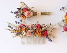 two combs with flowers on them sitting next to each other in front of a white wall