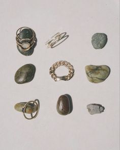 several different types of rings and rocks on a white surface