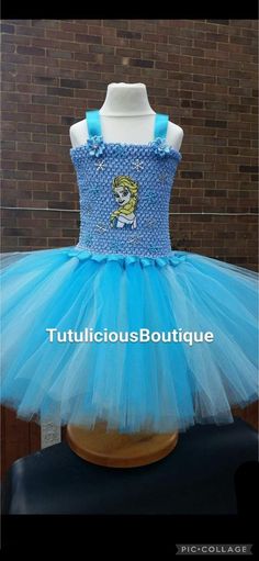 Frozen tutu dress. Beautiful muti toned blue skirt, lined with ribbon around the top knots. Blue crochet top with Elsa image and snowflakes all around. Beautiful mini white Bows going down the spine with a big blue bow at the bottom. Flowers at the base of the straps. Frozen Tutu Dress, Elsa Images, Blue Crochet Top, Frozen Tutu, Top Knots, Blue Crochet, White Bow, Blue Bow, Big Blue