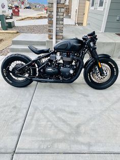 a black motorcycle parked in front of a house