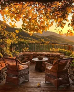 two wicker chairs sitting on top of a wooden deck next to a fire pit