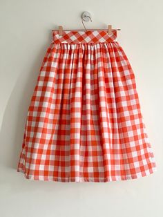 "Orange check high waist full gathered skirt. Perfect for casual outfits and special ocasions with pair of trainters or high heels. 100% cotton.  Elastic at the back of waist.  Two side pockets. Midi lenght about 70cm + 5 cm waistband. Handmade in UK.  Model wears size S.  HOW TO CHOOSE A SIZE ?   Using a measuring tape, measure the smallest part of your waist.  SIZE CHART: (CM) XS - W: 66 CM S - W: 70 CM M - W: 74 CM  L - W: 78 CM  XL - W: 82 CM  CARE INSTRUCTIONS: Hand wash only, do not bleach, hang dry, do not tumble dry, press with a cool iron on the reverse side.  Please message me before purchasing so I can check availability. If you wish this skirt in any other fabric, shorter or longer \"send message to seller\" and we can try to make something especially for you. *Depends on compu Summer Plaid Pleated Skirt, Plaid Cotton Lined Skirt Bottoms, Plaid Long Skirt For Spring, Fitted Cotton Skirt For Picnic, Plaid Cotton Long Skirt, Plaid Long Cotton Skirt, Plaid Cotton Relaxed Skirt, Long Plaid Cotton Skirt, Gingham Skirt For Summer Picnic