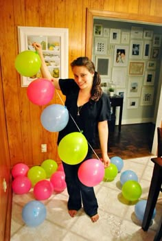 a woman is holding balloons in her hand