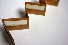 three pieces of brown paper sitting on top of a white table next to each other