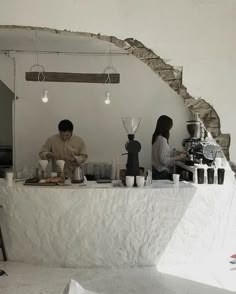 two people sitting at a table with food on it