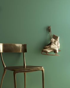 a pair of ice skates hanging on the wall next to a chair