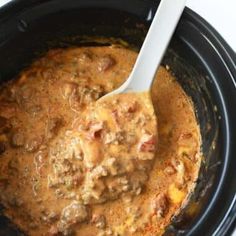 a spoon in a slow cooker filled with food