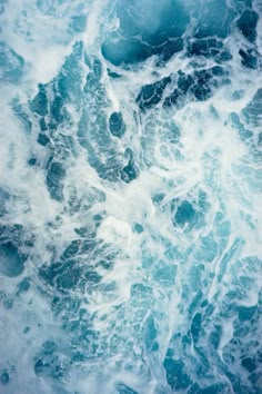 the water is blue and foamy with small bubbles on it's surface, as seen from above