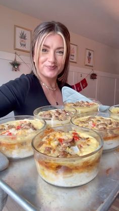 a woman sitting at a table filled with pies