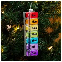 an ornament hanging from a christmas tree with seven days of the week written on it