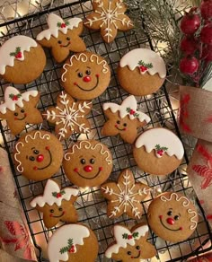 cookies decorated with icing and snowflakes are on a cooling rack next to christmas decorations