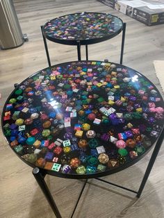 two tables with different colored dices on them in a store display area, one is black and the other is multicolored