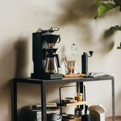 a coffee maker sitting on top of a metal shelf