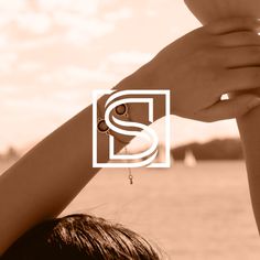 a woman's arm and hand with the letter s on it, in front of a body of water