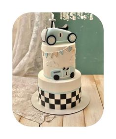 a three tiered cake with a car on the top and checkerboard design