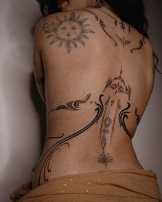 a woman's back with tattoos on her body and an arrow in the middle