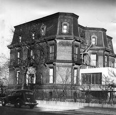 an old black and white photo of a house with a car parked in front of it