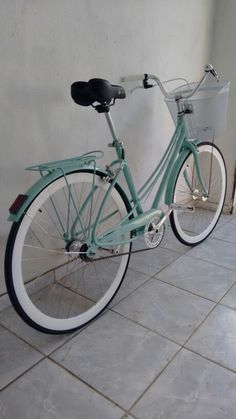 a blue bicycle parked next to a white wall