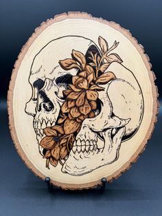 a wooden plate with a skull and flowers on it