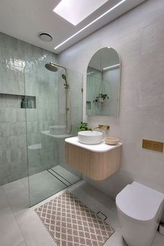 a bathroom with a toilet, sink and shower stall in the middle of it's walls