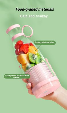 a hand holding a blender filled with fruit and veggies on top of it