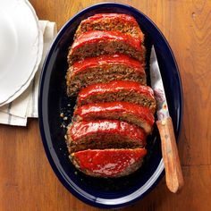 sliced meatloaf with ketchup on a blue plate