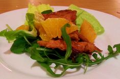 a white plate topped with lettuce and orange slices