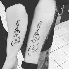 two people with matching guitars tattoos on their arms, one has a guitar and the other has a musical note