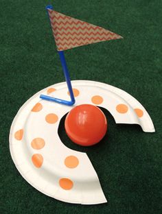 a paper plate with an orange and white polka dot design on it, next to a small flag