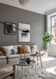 a living room filled with lots of furniture and a potted plant on top of a table