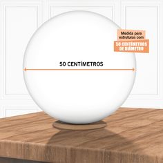 a white ball sitting on top of a wooden table next to a sign that reads 50 centimeros