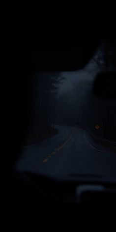 a car driving down a dark road at night