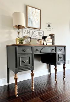 an antique desk with two drawers and a lamp