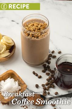 breakfast coffee smoothie with banana slices and granola next to it on a marble countertop