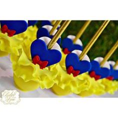 blue, yellow and red heart shaped lollipops are lined up in rows